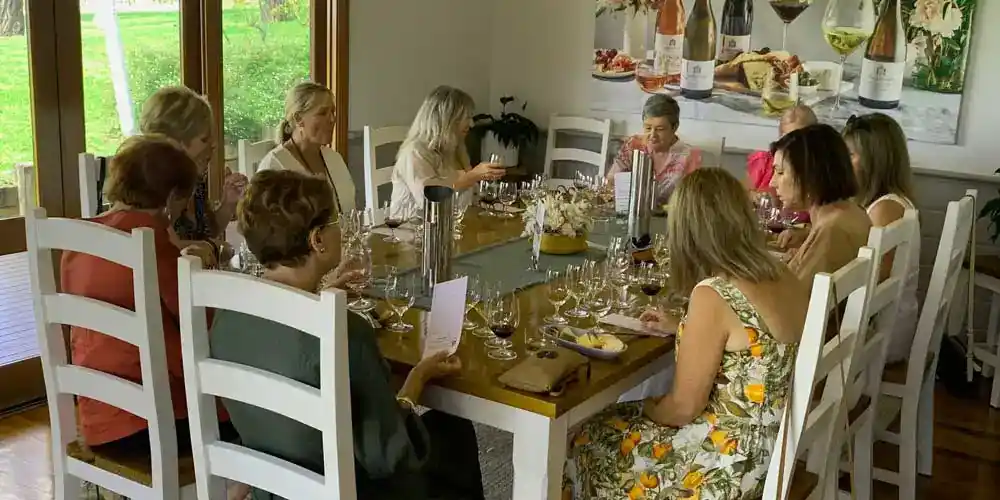 Hunter Valley Wine Tours 8 A group of 10 middle-aged women sitting around a large square wooden table, enjoying a private wine tasting