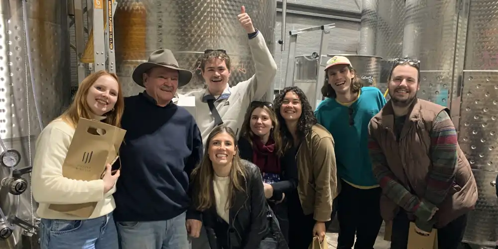 group of seven young people pay for wine tasting on paid wine tour at hunter wine lab in the hunter valley