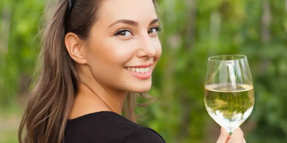 beautiful brunette woman enjoying a glass of semillon wine